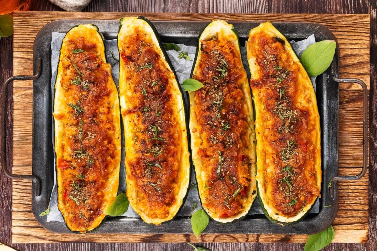 4 Stuffed Zucchini on a board.