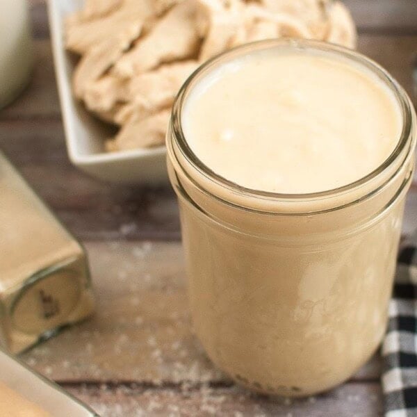 jar of cream soup on a board with checkered napkin and chicken in background.