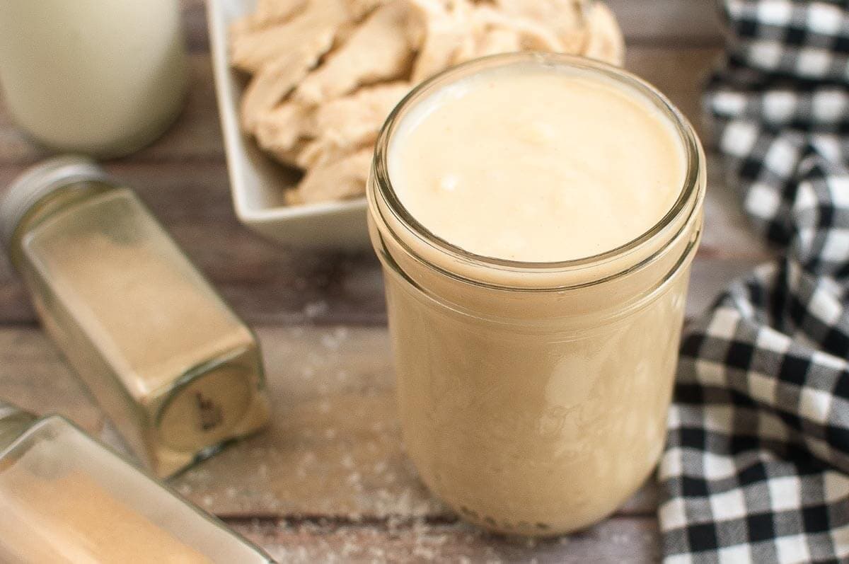jar of cream soup on a board with checkered napkin and chicken in background.