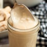 Homemade Condensed Cream of Chicken Soup in a jar with some on a spoon.