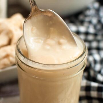 Homemade Condensed Cream of Chicken Soup in a jar with some on a spoon.