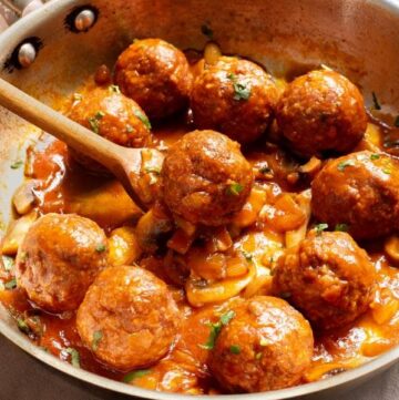 Salisbury Steak Meatballs in a skillet with spoon.