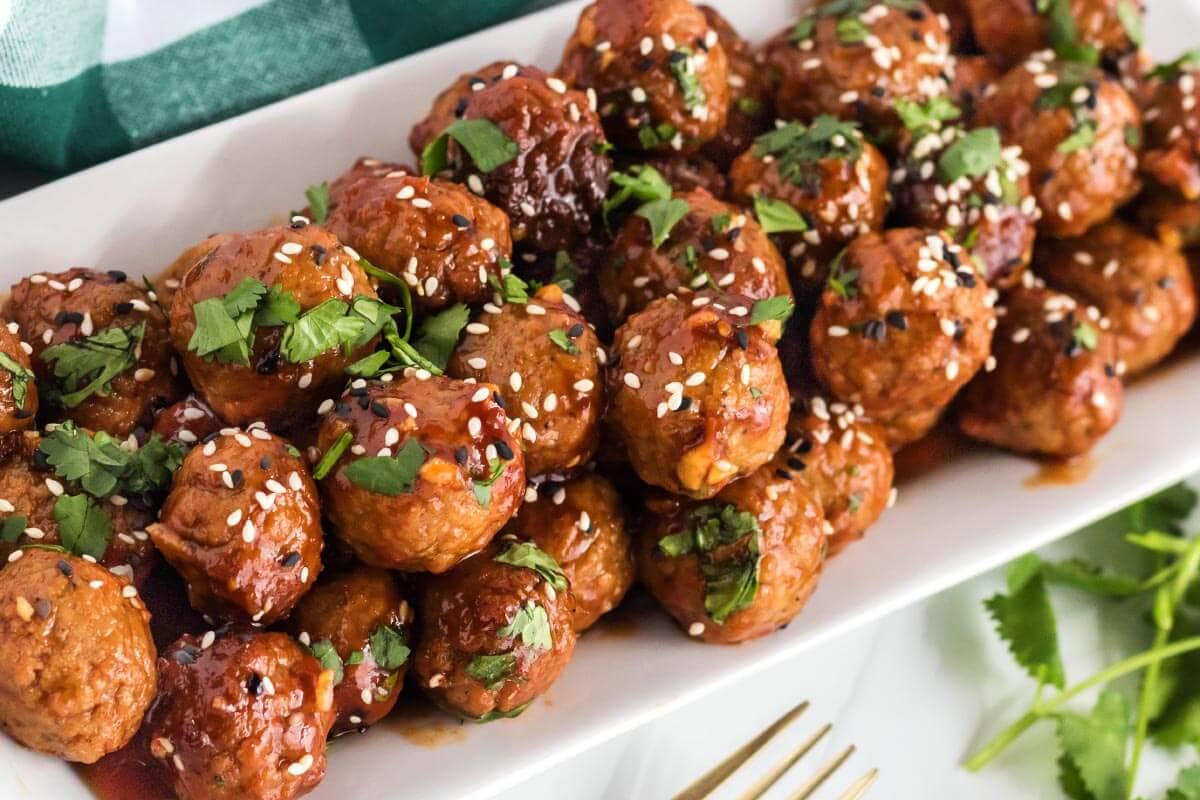 meatballs on a white plate with sesame seeds