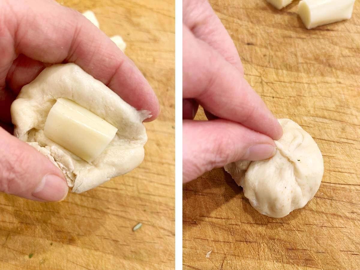 filling dough ball with chunk of cheese.
