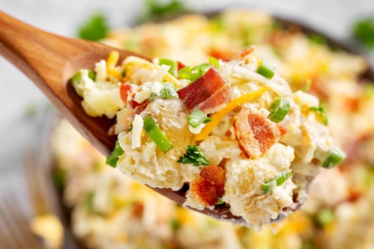 Loaded Potato Salad on wood spoon closeup