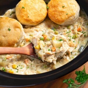 Slow Cooker Chicken Pot Pie in crock with ladle & biscuits