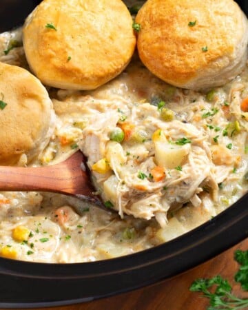 Slow Cooker Chicken Pot Pie in crock with ladle & biscuits