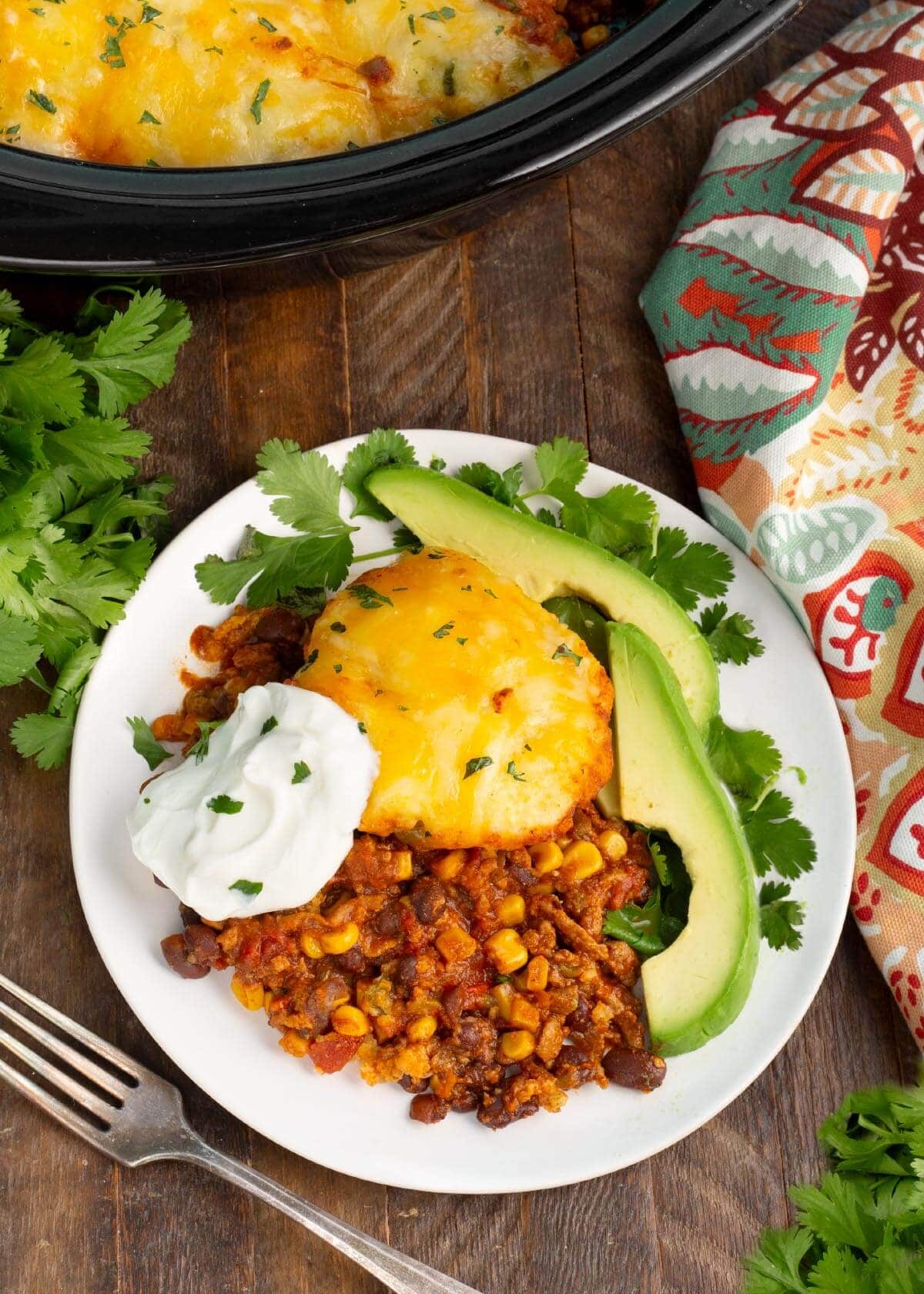 Slow Cooker Tamale Pie on a white plate with garnish.