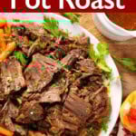 Apple Cider Pot Roast on a white platter with carrots and potatoes.