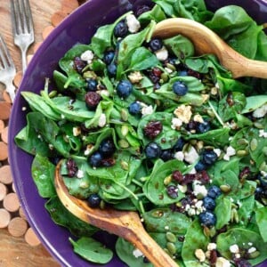Blueberry Spinach Salad in a purple bowl with wood spoons