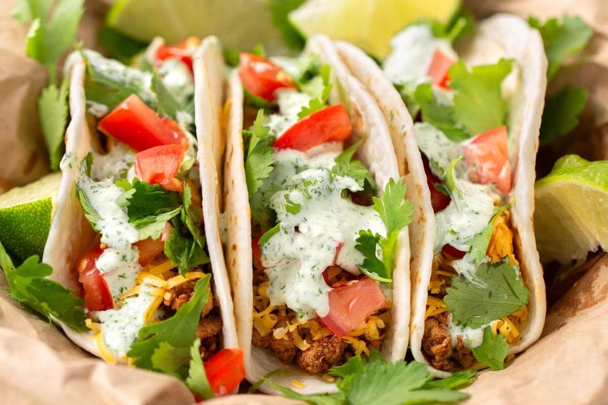 3 tacos with Cilantro Cream Sauce and garnishes