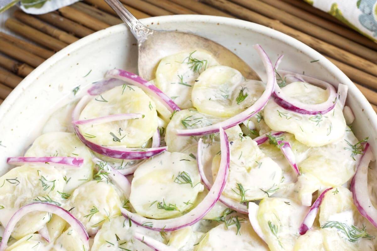Creamy Dill Cucumber Salad in a bowl with a spoon closeup.