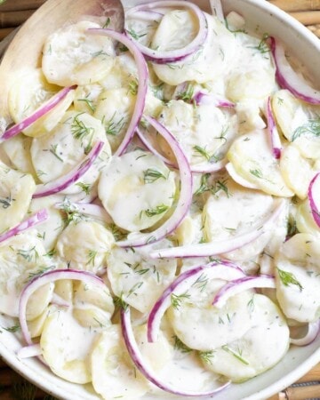 Creamy Dill Cucumber Salad in a white bowl closeup.