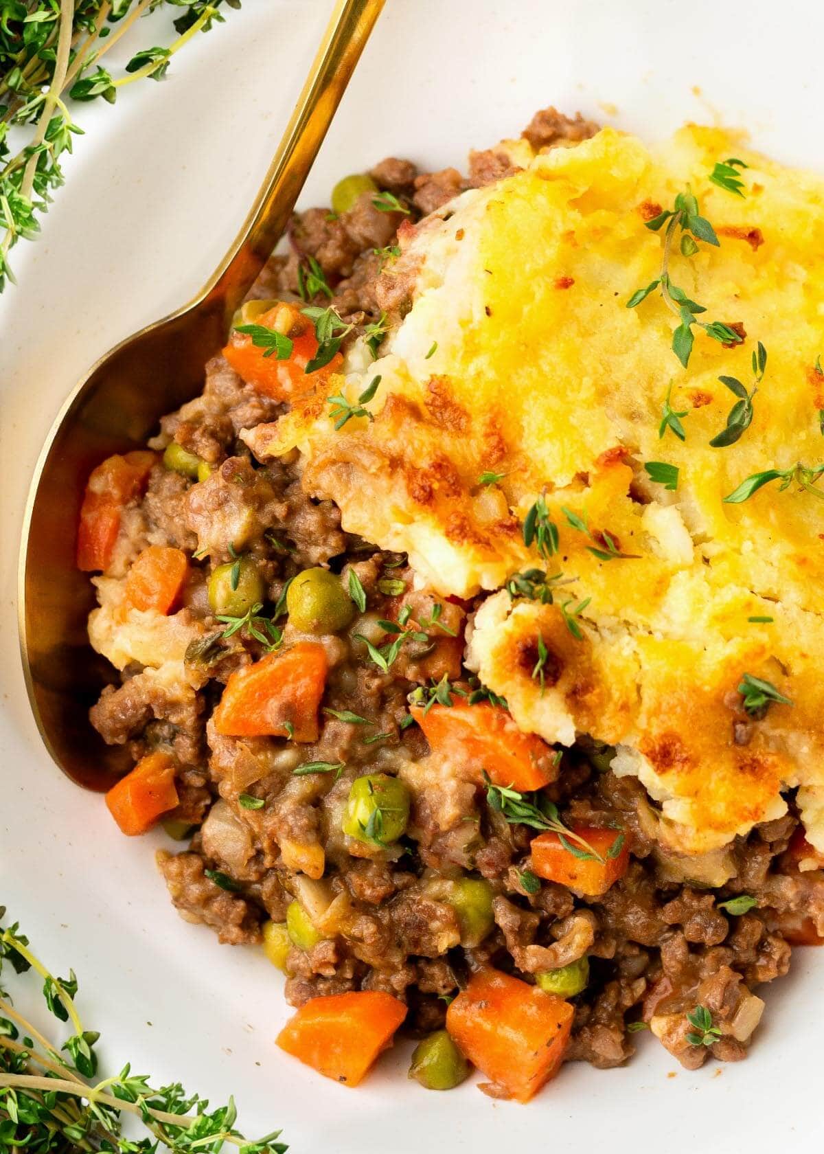 Irish Cottage Pie in a white bowl with a spoon.