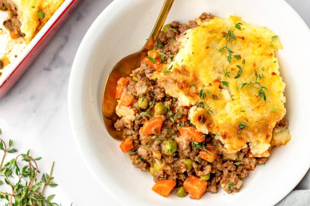 Irish Cottage Pie in a white bowl with a spoon.