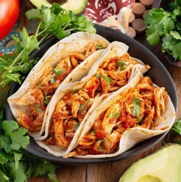 Easy Baked Salsa Chicken in 3 tacos on a plate with garnishes