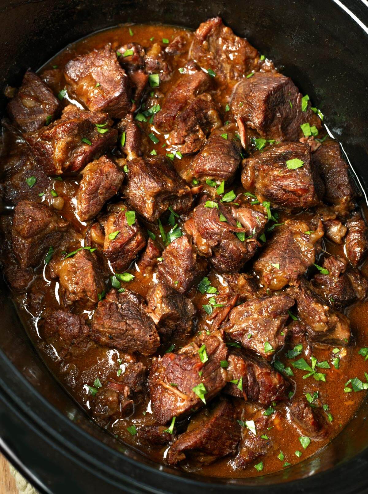 Slow Cooker Garlic Butter Steak Bites in black crock