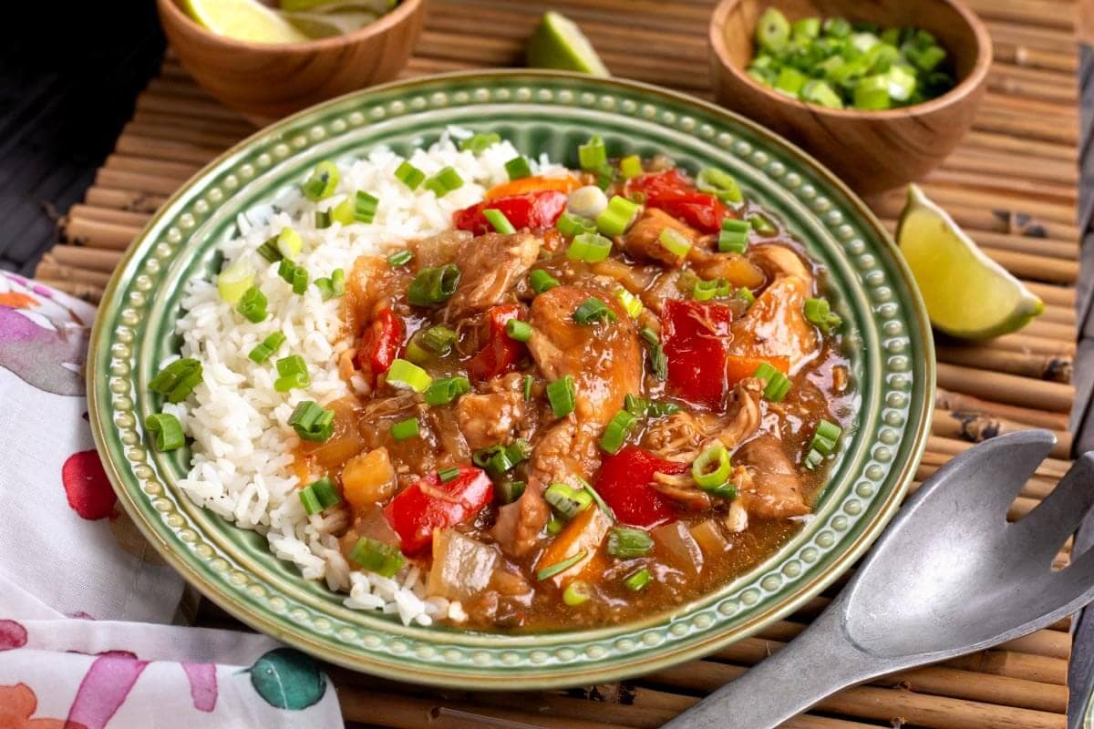 Slow Cooker Pineapple Chicken on a green plate with rice
