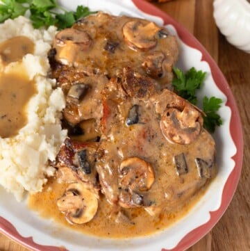 Slow Cooker Pork Chops with Mushroom Gravy and mashed potatoes on a plate.