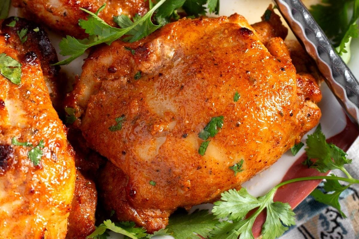 closeup of baked chicken thigh cooked in buttermilk marinade.