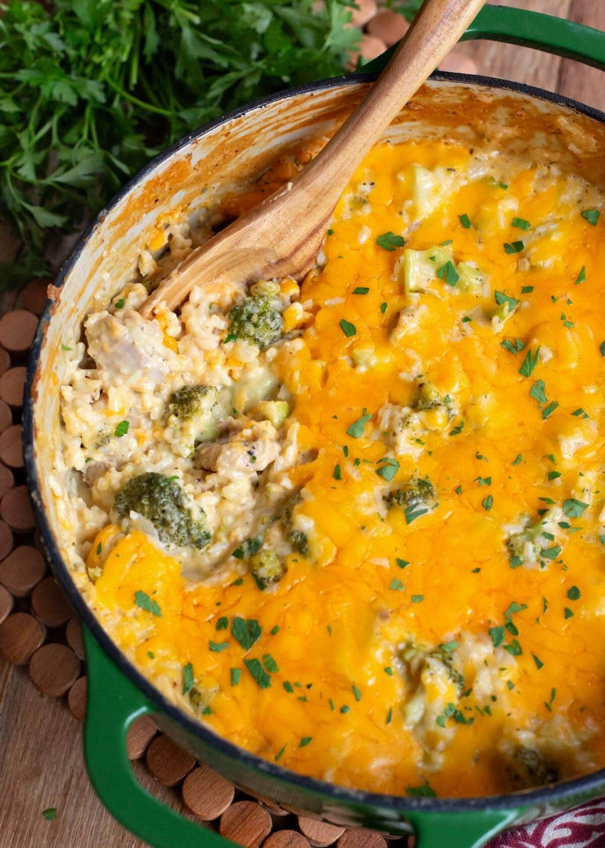 Cheesy Chicken Broccoli Rice Casserole in a pot with wood spoon