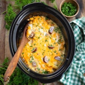 Crockpot Cheesy Potatoes with Kielbasa in a black crock