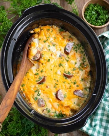 Crockpot Cheesy Potatoes with Kielbasa in a black crock
