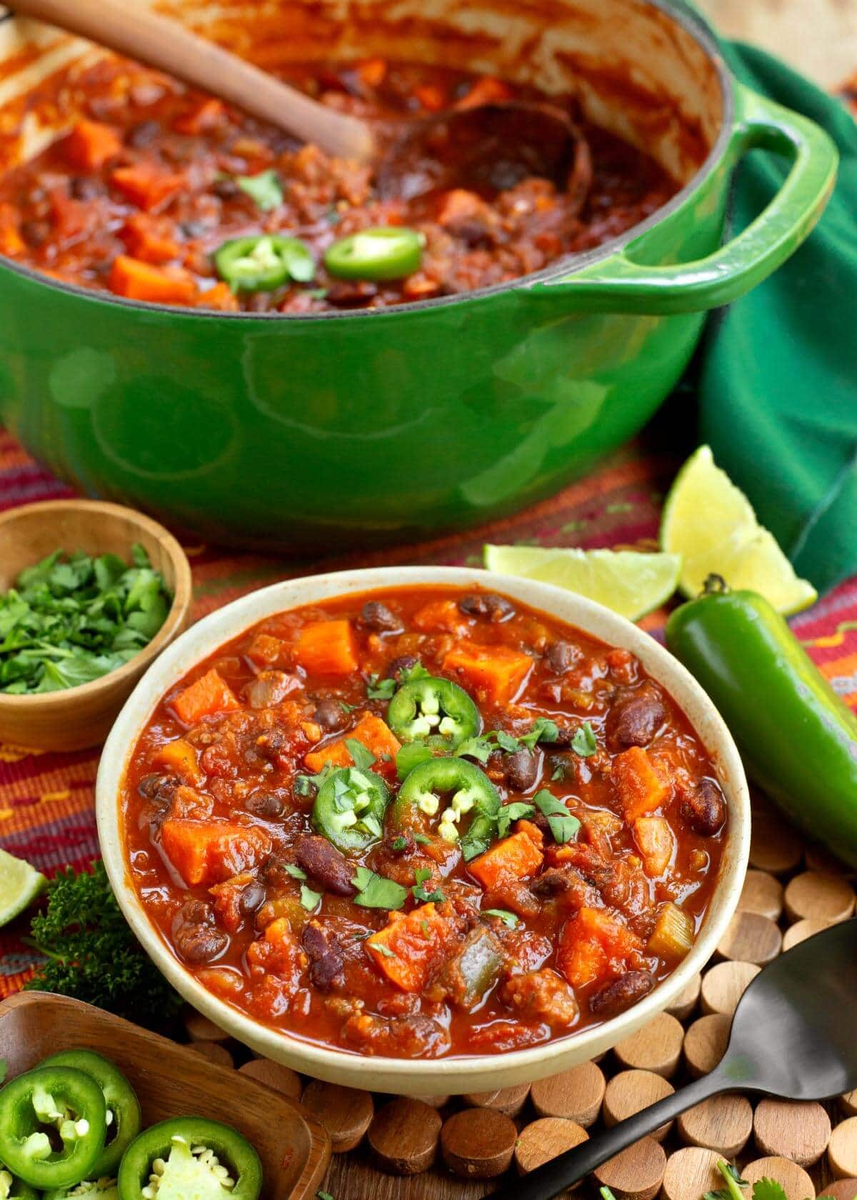 Sausage Sweet Potato Chili in a bowl with green pot behind