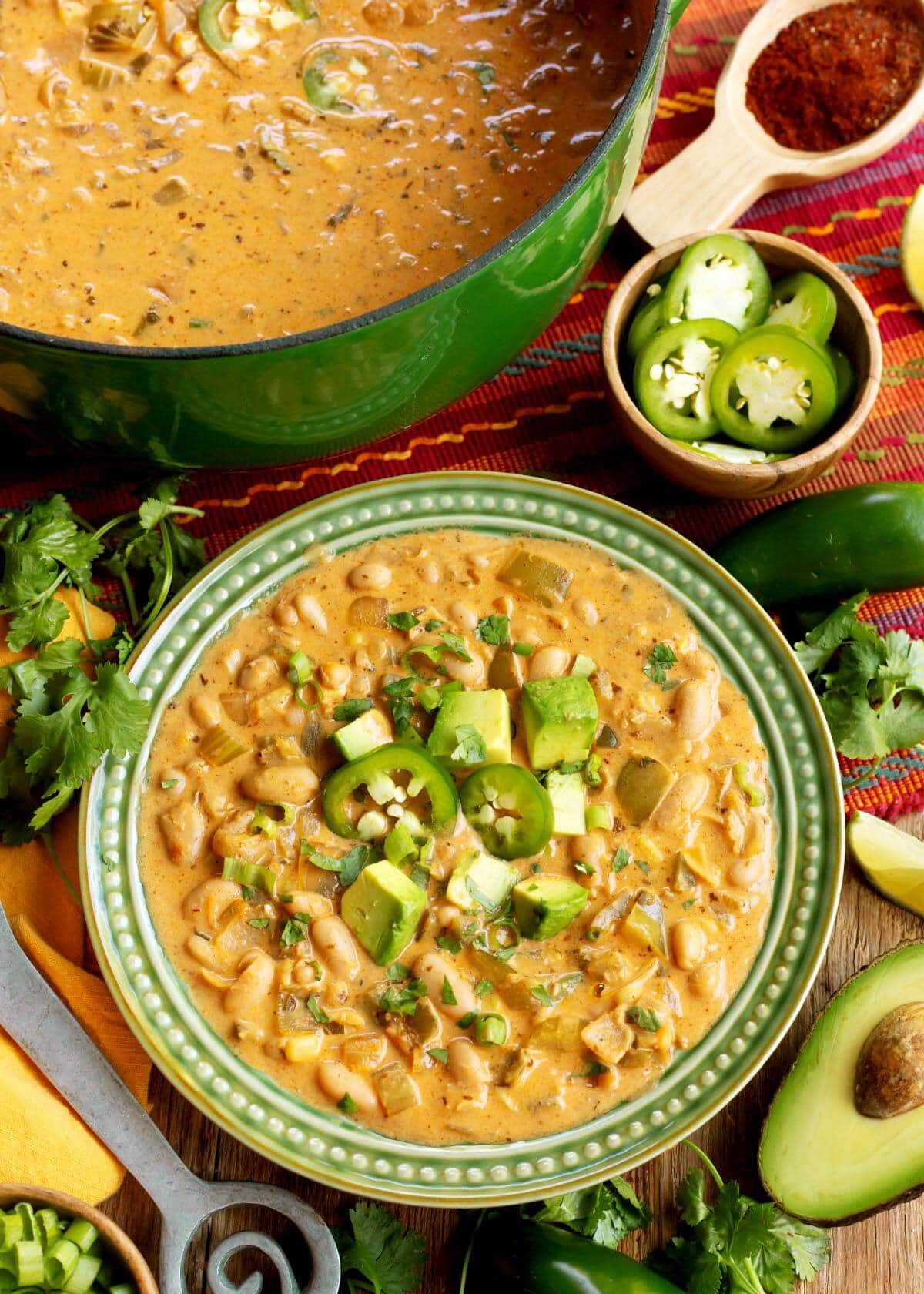 Vegetarian White Bean Chili in a green bowl and a green pot
