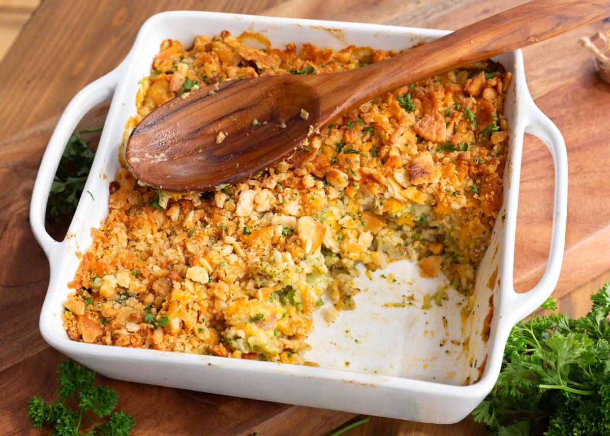 baking dish with a portion removed from the casserole, and wood spoon