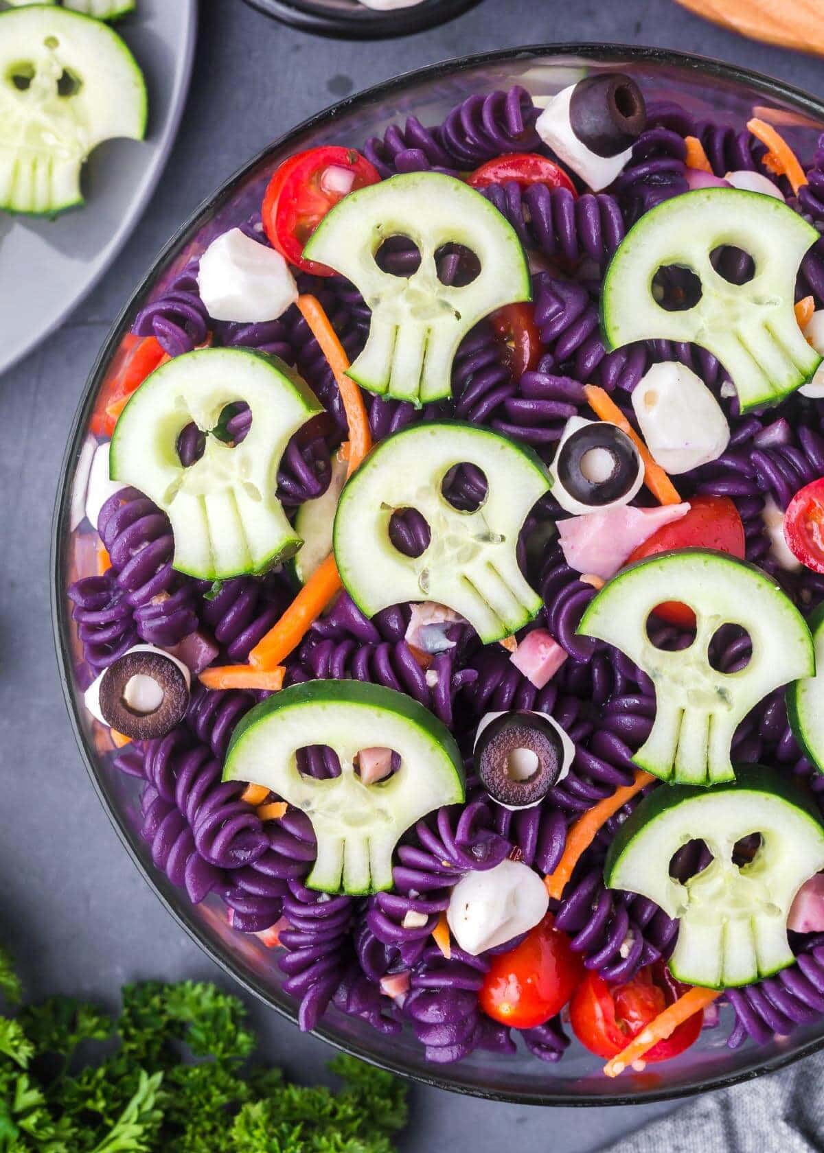 Skull Halloween Pasta Salad, Purple Halloween pasta salad decorated with cucumber skulls