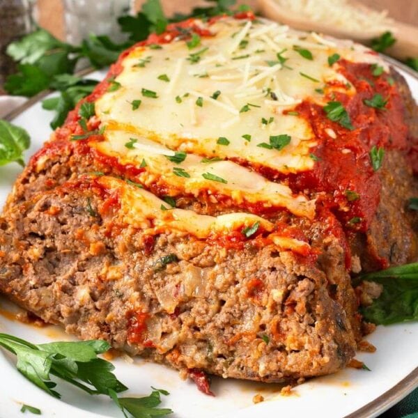 italian meatloaf partially sliced on a white platter