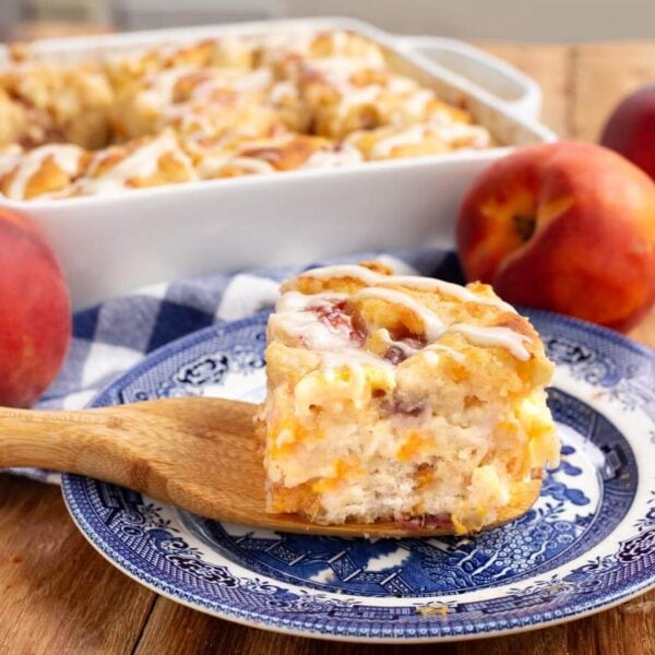 peach butter swim biscuit on a blue plate with baking dish full behind