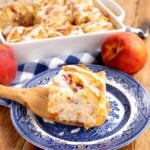 peach butter swim biscuit on a blue plate with baking dish full behind