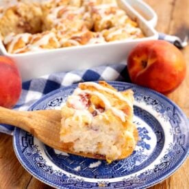 peach butter swim biscuit on a blue plate with baking dish full behind