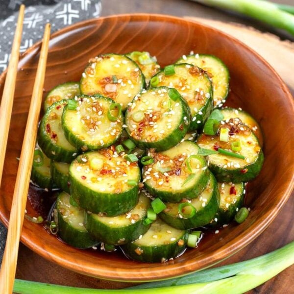 Asian cucumber salad in a wood bowl with chopsticks on the side