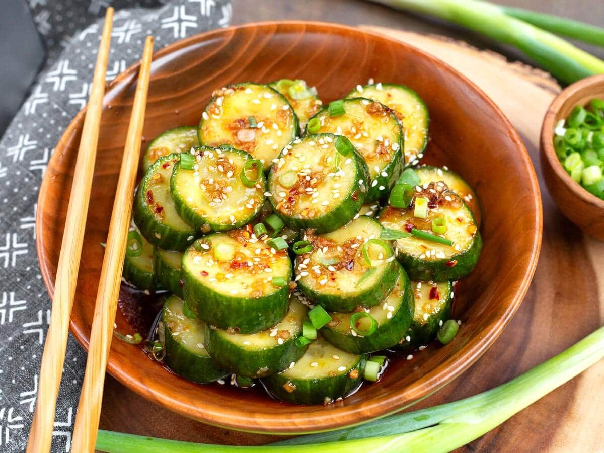 Asian cucumber salad in a wood bowl with chopsticks on the side