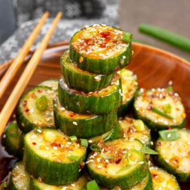 Asian cucumber salad in a wood bowl with chopsticks on the side