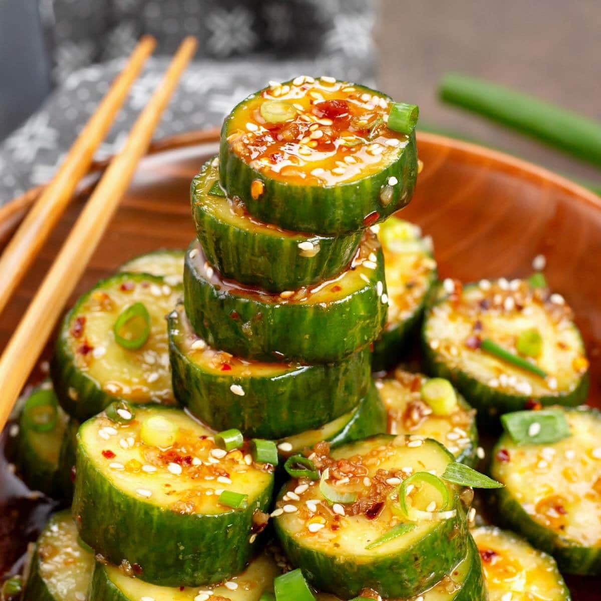 Asian cucumber salad in a wood bowl with chopsticks on the side