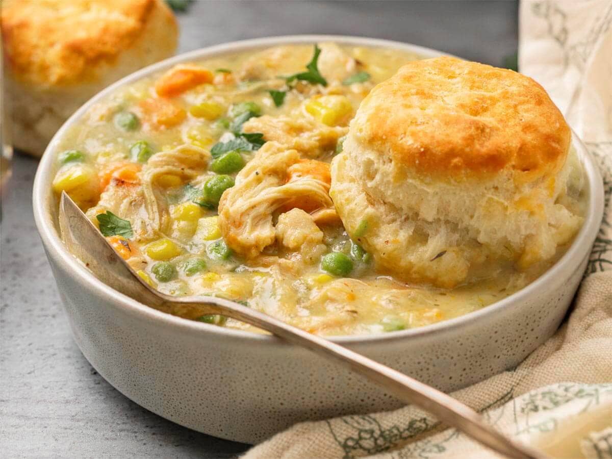 Bowl of Instant Pot Chicken Pot Pie with creamy chicken and vegetables, topped with a golden biscuit