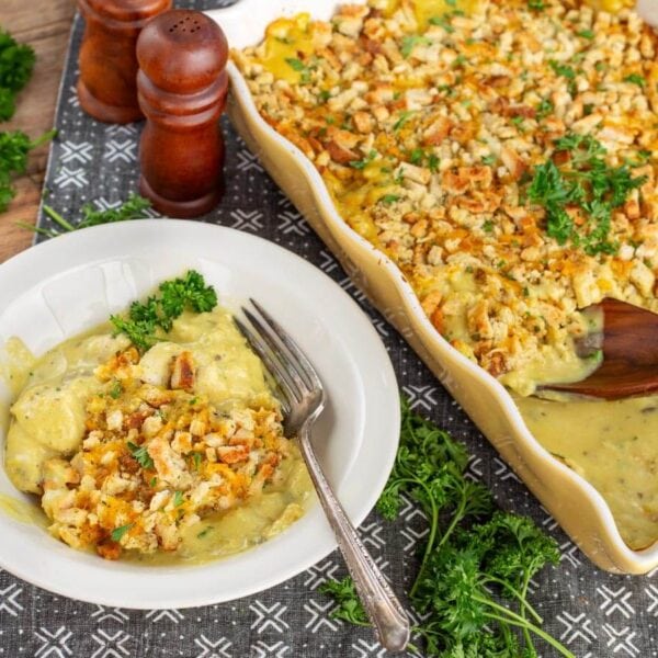 Chicken and stuffing casserole served on a white plate with the baking dish in the background