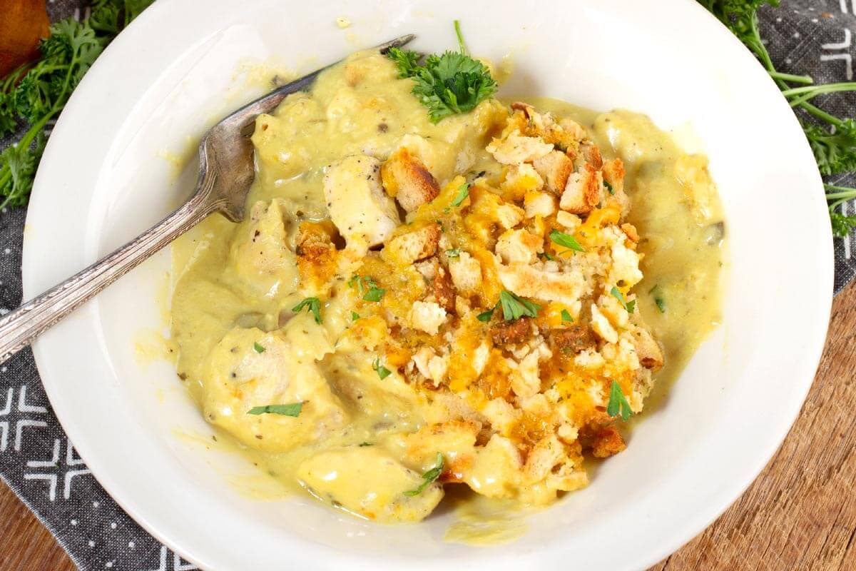 Close-up of creamy chicken and stuffing casserole with pieces of chicken beneath the crisp stuffing topping