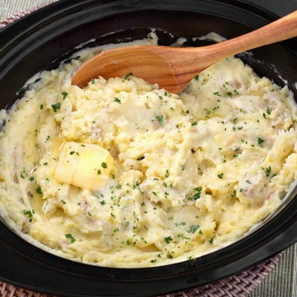 Creamy crockpot mashed potatoes with butter and parsley, ready to serve from the slow cooker