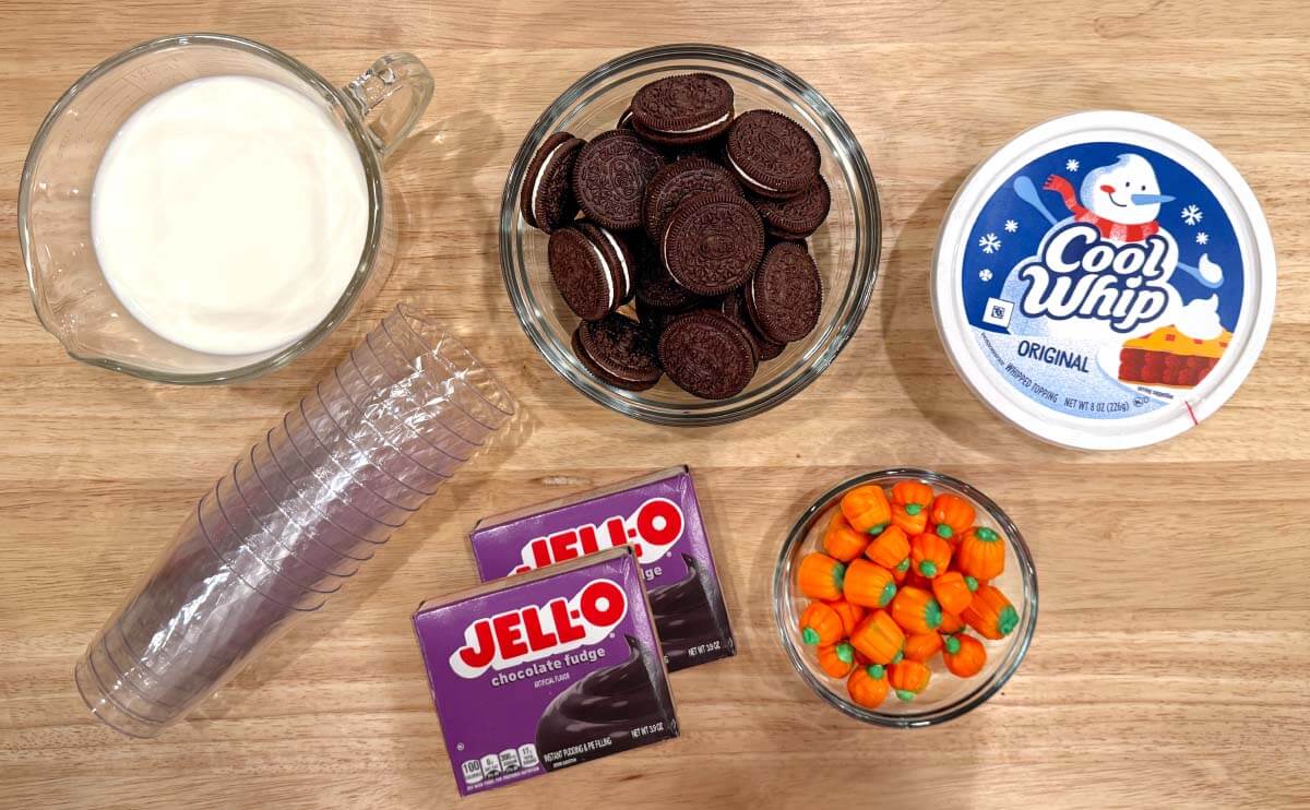 Chocolate pudding mix, milk, Cool Whip, Oreo cookies, candy pumpkins, and clear dessert cups for Pumpkin Patch Dirt Cups