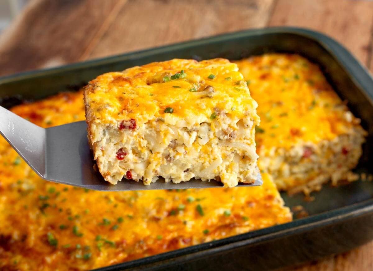 Sausage hashbrown breakfast casserole with a serving on a spatula