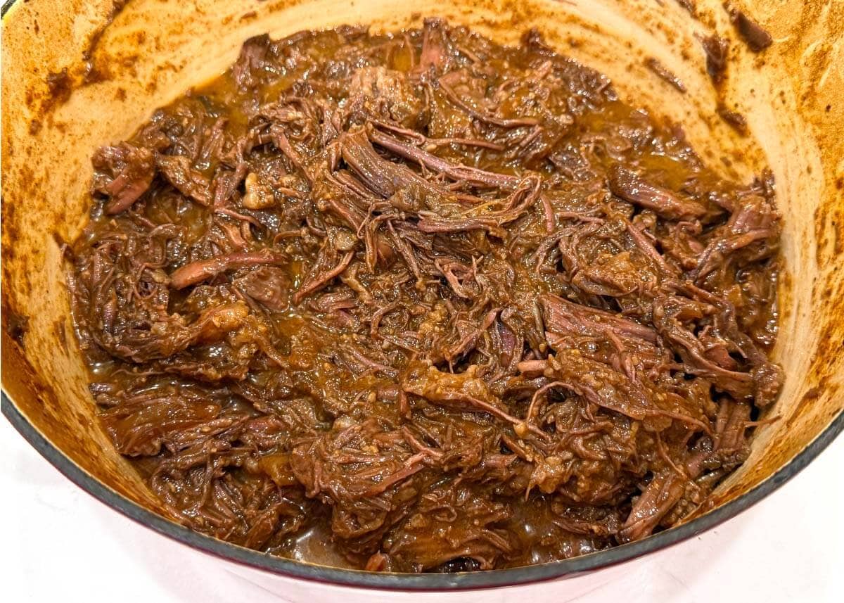 Tender shredded barbecue beef in a Dutch oven
